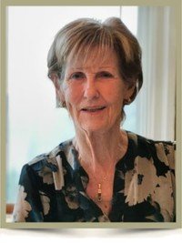 Elderly woman smiling in floral blouse.