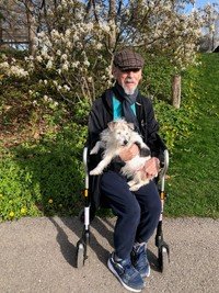 Man with dog sitting on walker outdoors