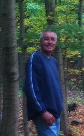 Person smiling among trees in a forest