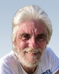 Smiling man with white hair and beard.