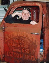 Man in vintage truck with rusty door