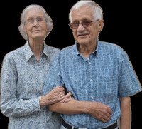 Elderly couple standing together, holding hands.