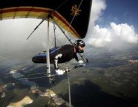 Person hang gliding over scenic landscape