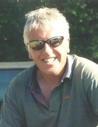 Smiling man wearing sunglasses outdoors.