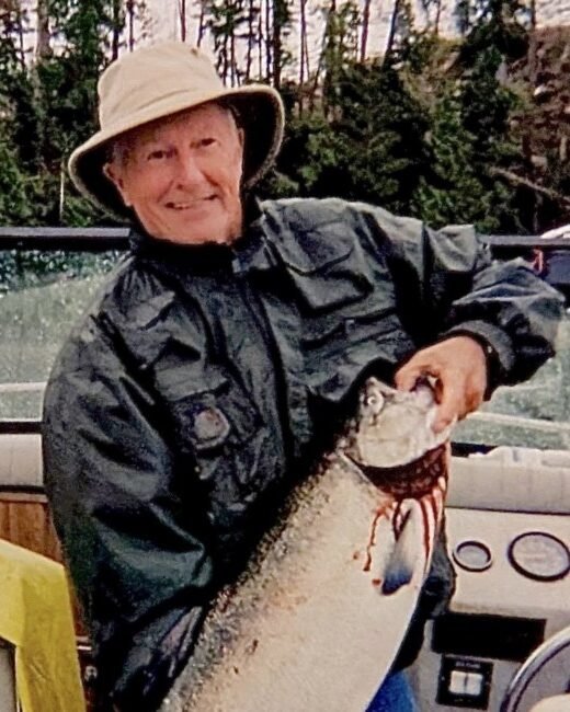 Person on boat holding a large fish, smiling.