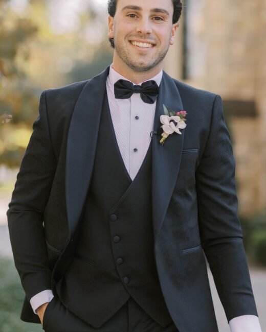 Man in tuxedo smiling outdoors