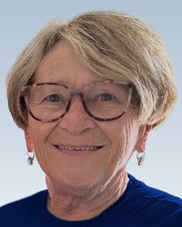 Smiling elderly woman with glasses and short hair.