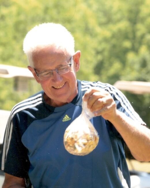Man holding a bag of mixed nuts outdoors.