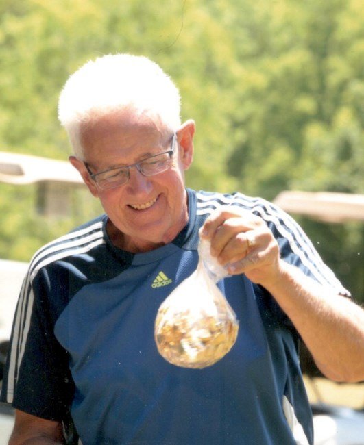 Man holding a bag of mixed nuts outdoors.