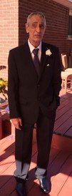 LARABIE, Roger Truman Larabie Man in suit standing on red wooden deck.