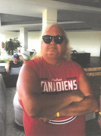 Person wearing sunglasses and Canadiens shirt indoors.