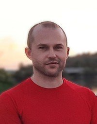 Person in red shirt outdoors at sunset