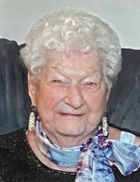 Smiling elderly woman with curly white hair.