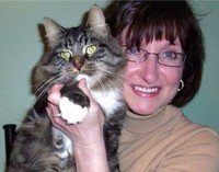 Woman holding a large tabby cat, both smiling.
