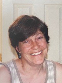 Smiling person in striped top near door