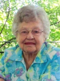 Elderly woman smiling in floral blouse outdoors