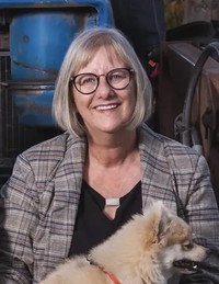 Woman smiling with dog in outdoor setting