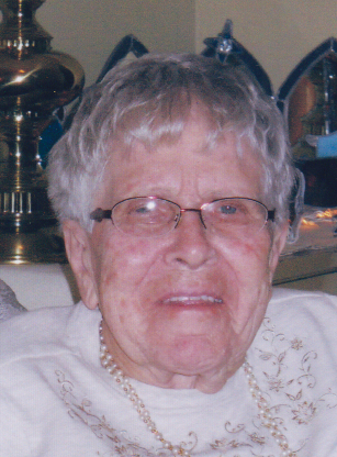 Elderly woman sitting and smiling indoors.