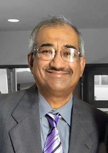 Smiling man in suit and tie indoors