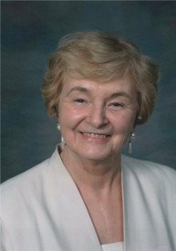 Smiling older woman with short hair and earrings.