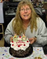 Woman celebrating with 60th birthday cake.