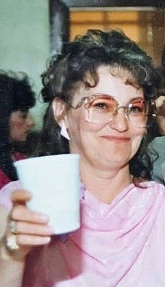 Smiling woman holding a cup at gathering