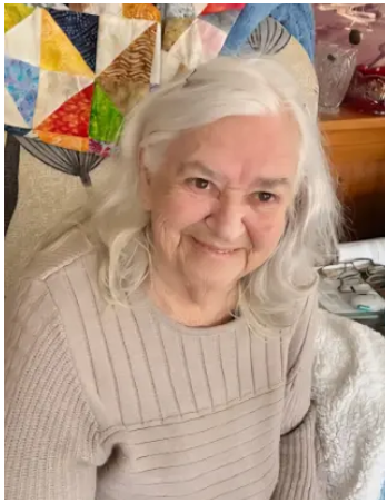 Smiling elderly woman with quilt background