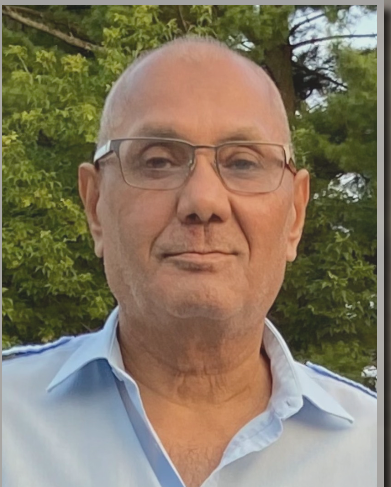 Smiling man outdoors with glasses and light shirt