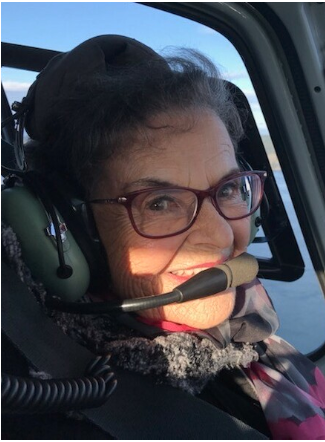 Smiling woman wearing a headset in a helicopter.