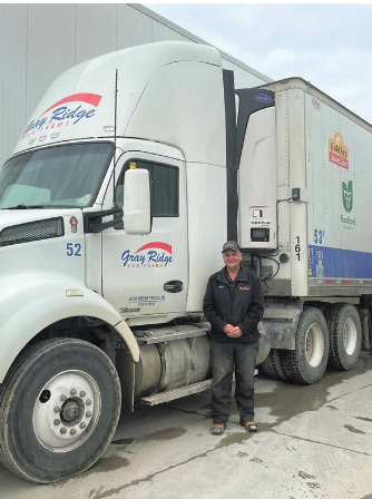 Truck driver standing beside delivery truck