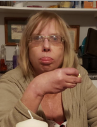 Person with glasses eating popcorn indoors.
