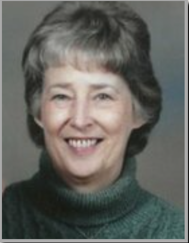 Smiling elderly woman in green sweater.