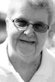 Elderly person smiling outdoors in black and white