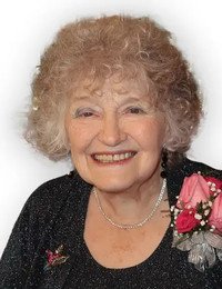 Smiling elderly woman with curly hair and flowers.