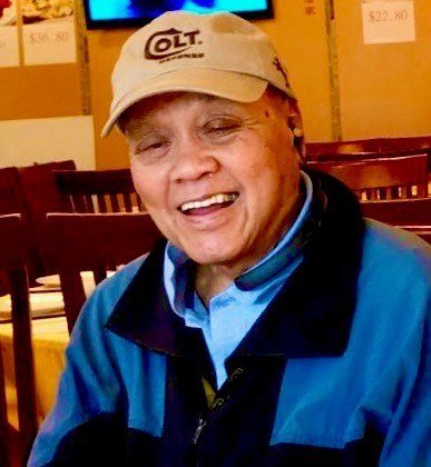Smiling person wearing a Colt hat indoors.