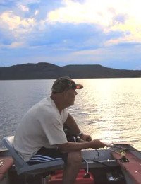 Man fishing on a lake at sunset
