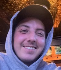 Smiling person in hoodie under warm lighting