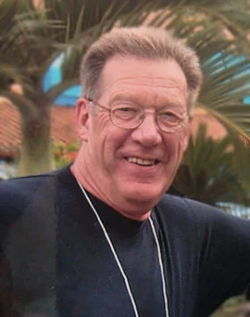 Smiling man outdoors with palm trees