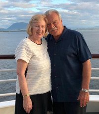 Couple smiling on a cruise ship deck.