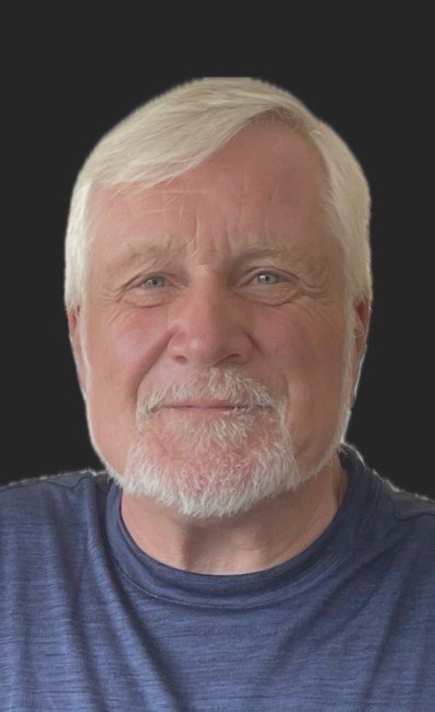 Smiling man with white hair and beard.