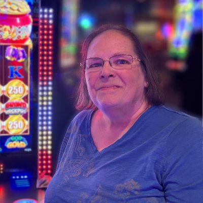 Woman smiling near slot machines in casino.