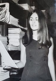 Woman reading document in front of shelves