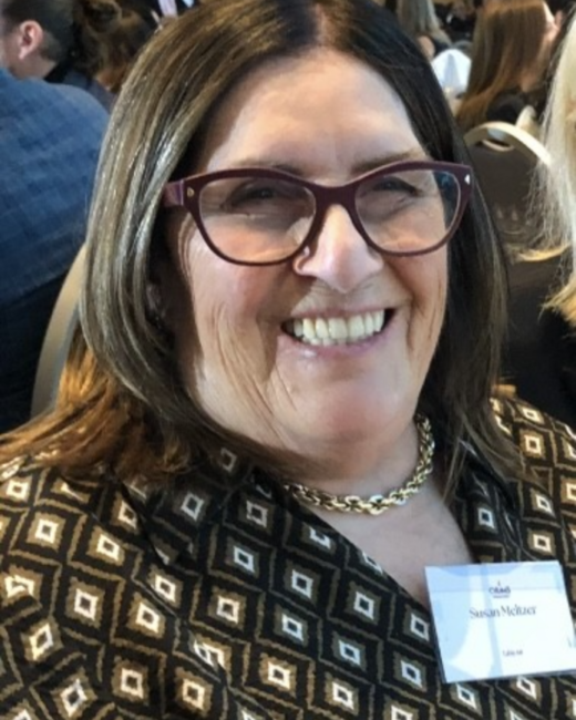 Smiling woman at an indoor event.
