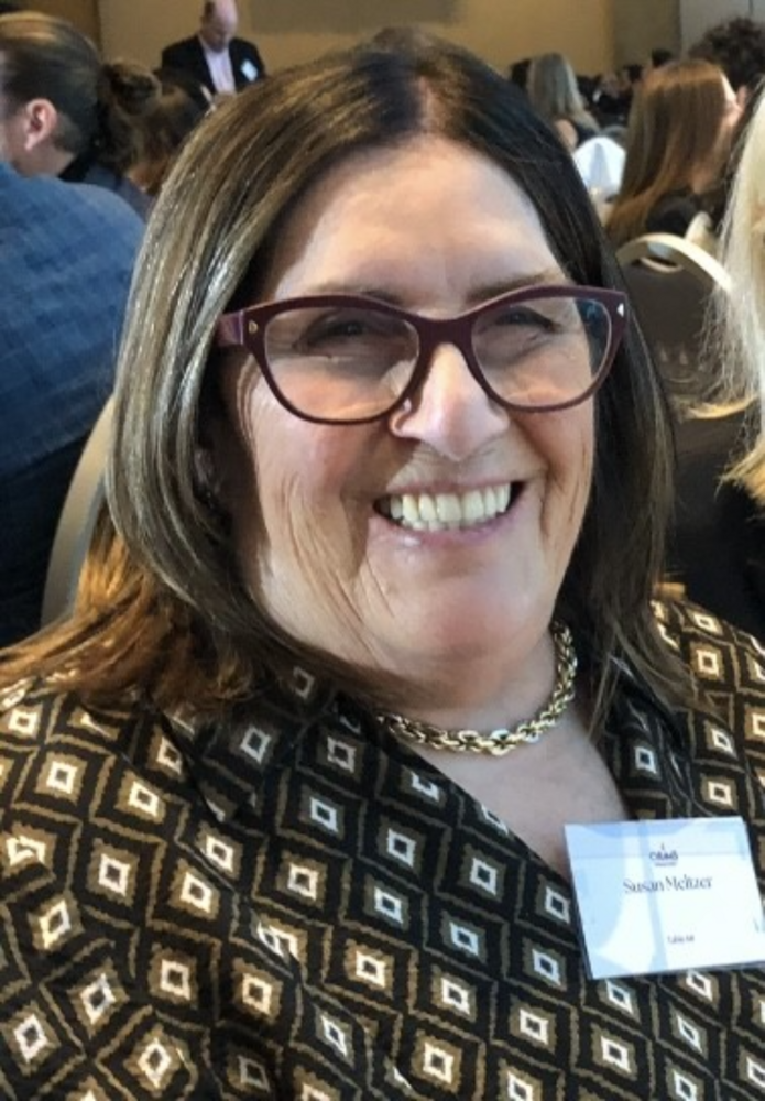 Smiling woman at an indoor event.