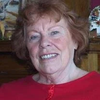 Smiling woman in red shirt indoors.