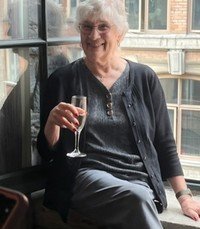 Smiling person holding a champagne glass indoors.