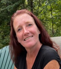 Smiling woman sitting outdoors in a garden