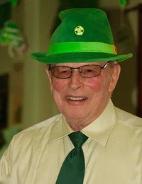 Smiling man in green hat and tie.