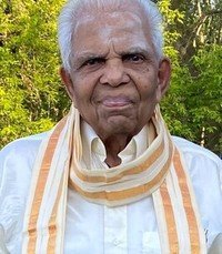 Elderly man outdoors with striped scarf and shirt.