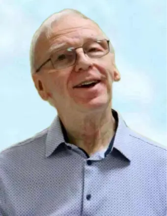 Smiling man wearing glasses and a light blue shirt.